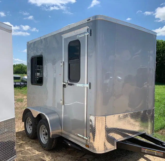 Silver 6 x 10 ft tandem-axle guard house trailer with entry door and side window